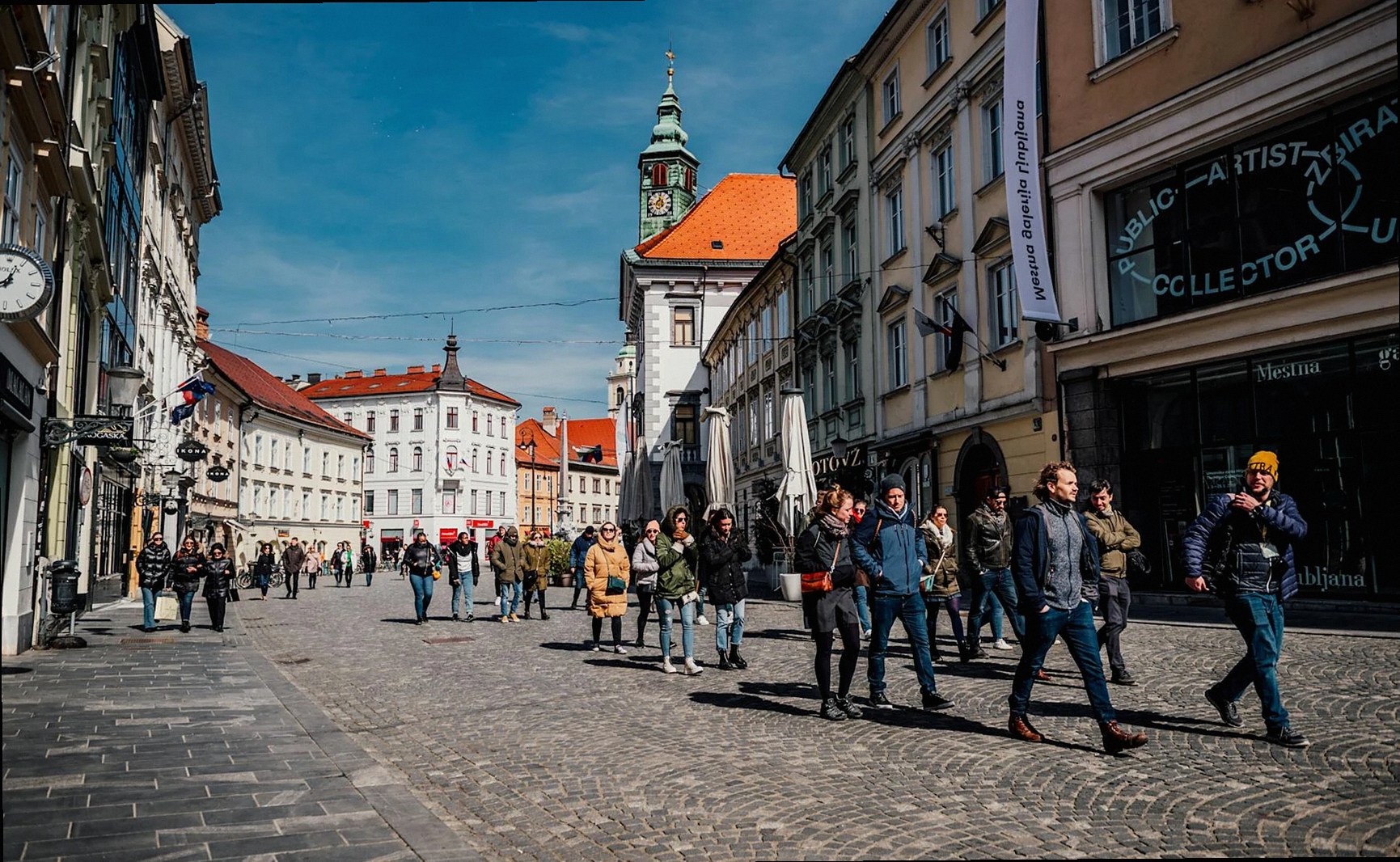 Escena urbana vibrante de personas caminando por una calle histórica en Liubliana, Eslovenia.